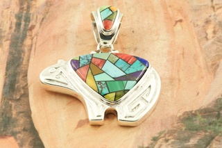 Stunning Mosaic featuring Genuine Sleeping Beauty Turquoise, Spiny Oyster Shell, Sugilite and Blue Lapis inlaid in Sterling Silver. Beautiful inlay on the bale and pendant. Free 18" Sterling Silver Chain with purchase of pendant. Bear Pendant Designed by Navajo Artist Calvin Begay. Signed by the artist.